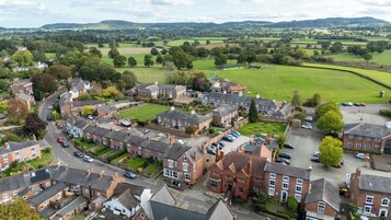 A residential area with houses, a road, and a green field.