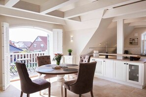 A modern kitchen with a dining area, large windows, and a view of the neighborhood. - Holiday apartment in Büsum with swimming pool (Büsum)