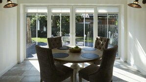 A dining area with a round table, six chairs, and a bowl of fruit. - Holiday apartment in Büsum with swimming pool (Büsum)