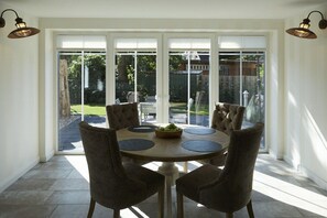 A dining area with a round table, six chairs, and a bowl of fruit. - Holiday apartment in Büsum with swimming pool (Büsum)