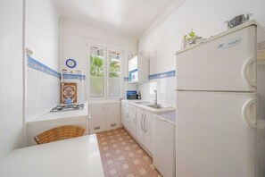 A compact kitchen with white cabinets, a microwave, a sink, and a refrigerator. - a/c 2BDR/4P appartement - Cannes center (Cannes)