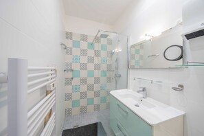 A bathroom with a shower, a sink, a mirror, and a towel rack. - a/c 2BDR/4P appartement - Cannes center (Cannes)