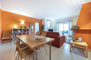 Ein modernes Wohnzimmer mit einem Holzesstisch, orangen Wänden und einem Sofa.