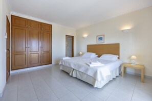 Ein Schlafzimmer mit einem großen Bett, einem Kleiderschrank und einer Badezimmertür.