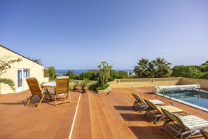 A patio with a pool, outdoor furniture, and a view of the sea. - Quinta da Belavista 55 by CoolHouses (Luz)