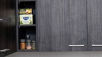 Una cocina con armarios de madera oscura, un hervidor de acero inoxidable y una cafetera.