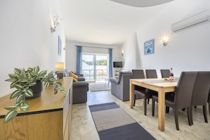 A modern living room with a dining area, a sofa, a coffee table, and a TV. - Casa Lília | Mte S Pedro 2 (Luz)