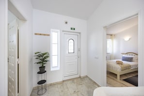 A hotel room with a bed, a bedside table, a potted plant, and a window. - Casa Lília | Mte S Pedro 2 (Luz)