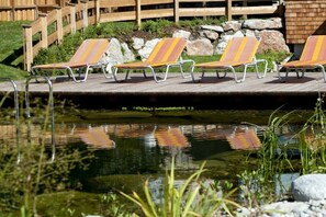 Ein Poolbereich mit Liegestühlen und einer Holzterrasse.