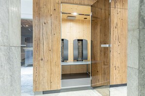 A modern elevator with wooden paneling and a metal frame, leading to a lower level. - Penthouse with 2 bedrooms (Reith bei Kitzbühel)