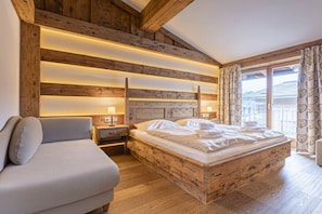 Une chambre à coucher avec une tête de lit en bois, un lit, une table de chevet et un canapé.
