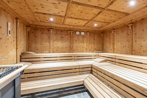 A sauna with wooden benches and a tiled floor. - Penthouse with 2 bedrooms (Reith bei Kitzbühel)