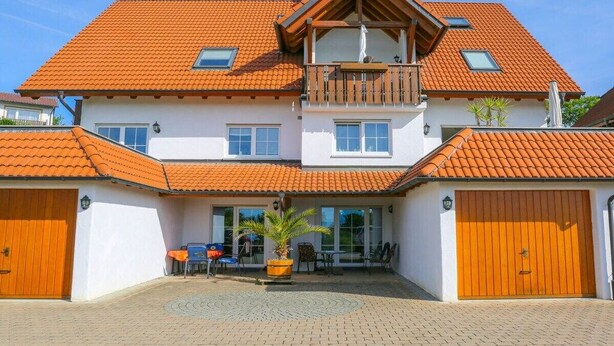 A two-story house with a red-tiled roof, a balcony, and a garage. - Holiday apartment with 1 bedroom (Meersburg)