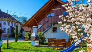 A wooden building with a chimney, a slide, and a picnic table. - Holiday apartment with 1 bedroom (Meersburg)