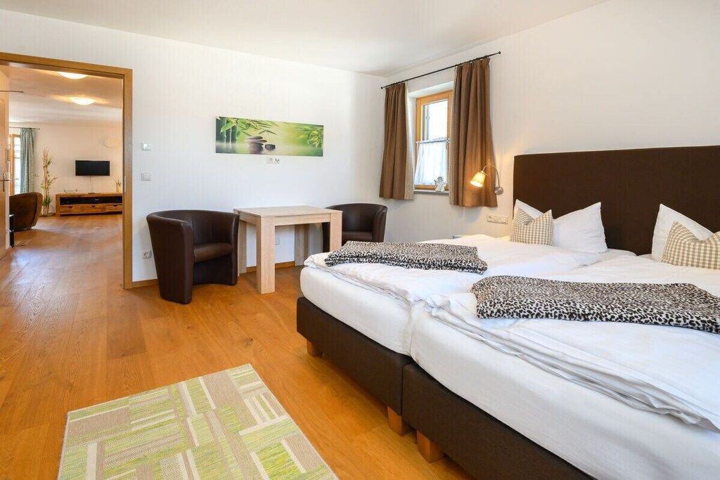 Habitació d'hotel amb llit, escriptori, cadira i televisió.