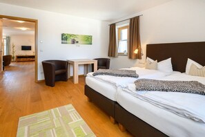 Une chambre d’hôtel avec un lit, un bureau, une chaise et un téléviseur.