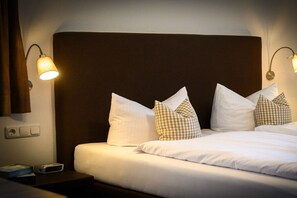 A neatly made bed with white bedding and multiple pillows, including a checkered one. - Holiday apartment with 1 bedroom (Farchant)