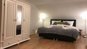 A bedroom with a bed, a wardrobe, and two bedside lamps. - Four Seasons || Bad Urach (Bad Urach)