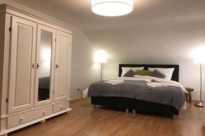 A bedroom with a bed, a wardrobe, and two bedside lamps. - Four Seasons || Bad Urach (Bad Urach)