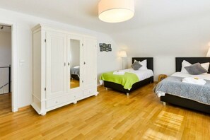 A bedroom with two beds, a wardrobe, and a ceiling light. - Four Seasons || Bad Urach (Bad Urach)