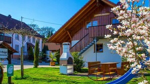 A wooden building with a slide, a barbecue area, and a bench. - Holiday apartment with 1 bedroom (Meersburg)
