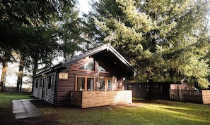 A lodge numbered 35 with a wooden exterior, large windows, and a sloped roof. - Sidlaw Spa (Dundee)