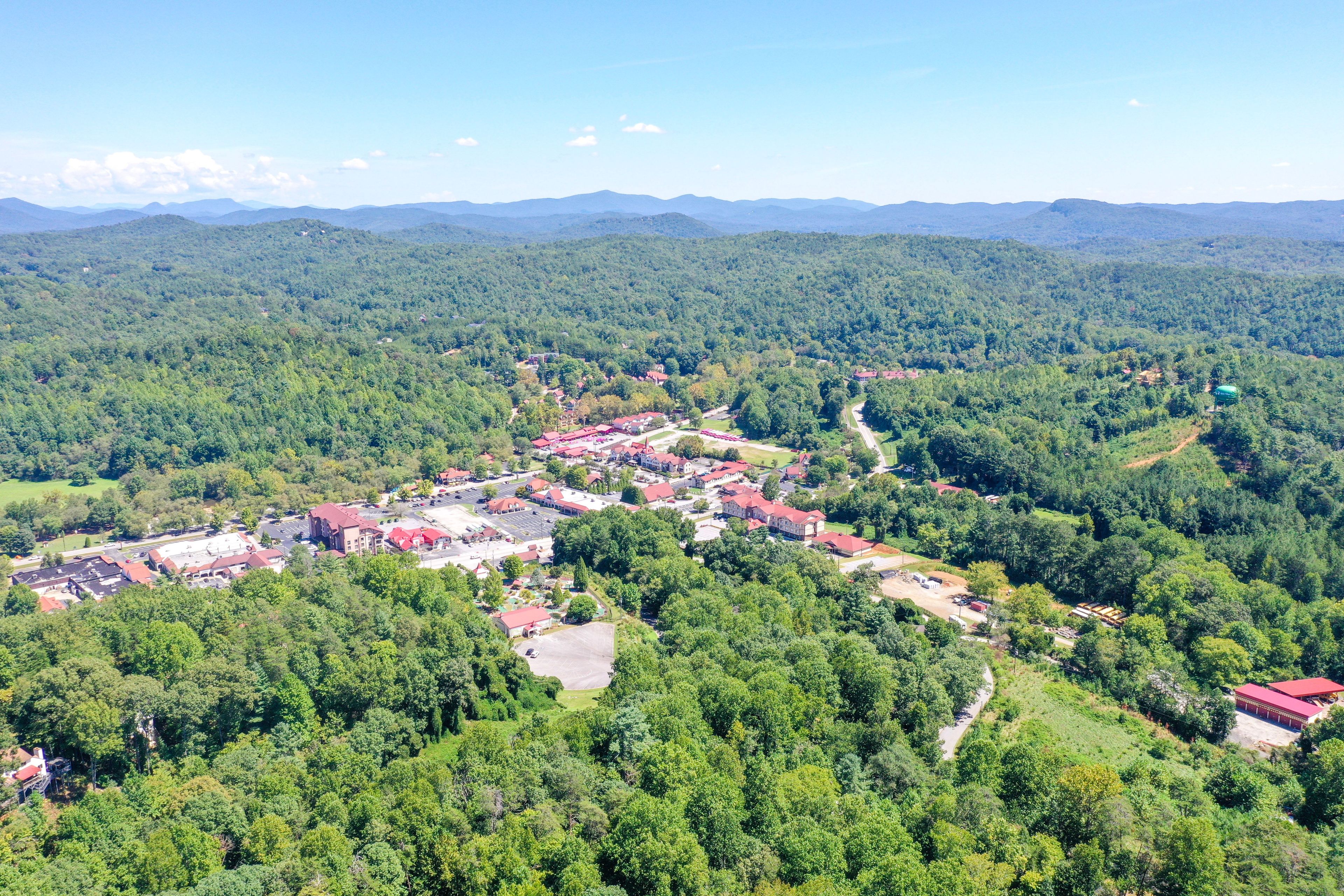 A town with a central cluster of buildings, surrounded by dense forest.