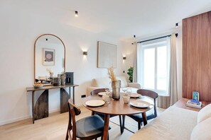A modern dining area with a round table, chairs, and a coffee station. - Résidence Laffitte (Paris)