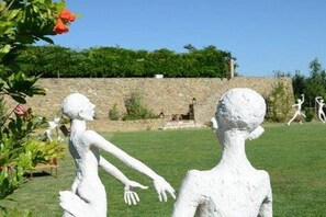 Ein Skulpturengarten mit weißen Statuen von Menschengestalten.