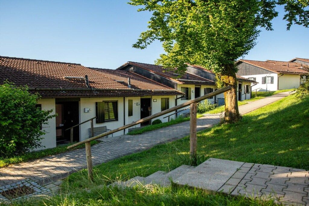 A row of traditional buildings with a paved pathway leading to the entrance.