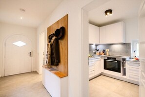 A modern kitchen with white cabinets, a wooden countertop, and a built-in oven.