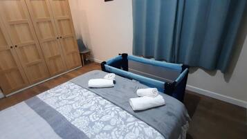 Ein Schlafzimmer mit einem Bett, einem Kleiderschrank und einem fenster mit Vorhängen.