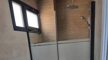 A modern bathroom with a toilet, bidet, and shower.