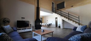 Un saló modern amb televisió, sofà, taula de centre i una llar de foc.