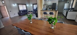 Un espai de viure modern amb zona de dinar, cuina i seients.