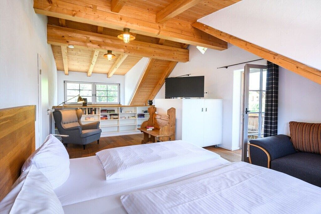 Un dormitorio con una cama grande, un escritorio, una silla, un televisor y una estantería.