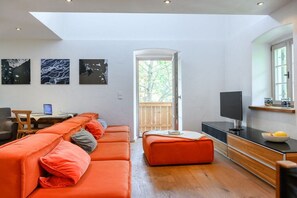 A modern living room with a sofa set, a television, and artwork on the wall. - Alpenkönig II in the Alpenkönig House (Garmisch-Partenkirchen)