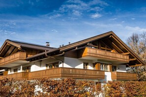 Eine zweigeschossige Chalet mit Holzbalkonen und einem geneigten Dach.