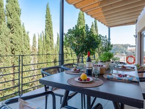 A balcony with a table set for dining, surrounded by tall trees and a clear view of the landscape. - Villa with private pool in Mancor de la Vall (Mancor de la Vall)