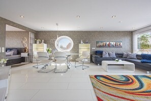 A modern living room with a sofa, chairs, a coffee table, and a colorful rug. - Holiday apartment with 1 bedroom (Wunstorf Steinhude)