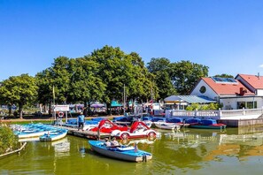 A marina with various boats docked, a building with a red roof, and a clear blue sky. - Holiday apartment with 1 bedroom (Wunstorf Steinhude)