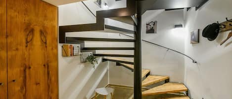 A modern interior with a spiral staircase, wooden flooring, and a minimalist design.