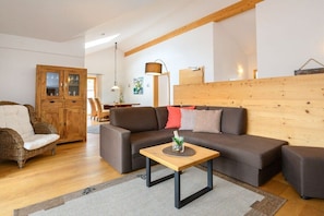 A living room with a brown sofa, a wooden cabinet, a small table, and a lamp. - Holiday apartment with 2 bedrooms (Farchant)