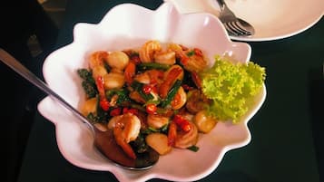 Un plato de comida con cuchara, tenedor y una ensalada en una mesa.