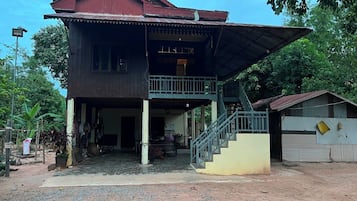A two-story house with a covered porch and a staircase leading to the upper level.