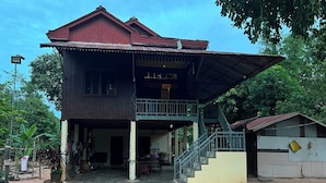 A two-story house with a covered porch and a staircase leading to the upper level.