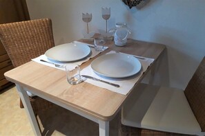 A dining table set with plates, cutlery, and a glass. - Holiday apartment with 2 bedrooms (Harsdorf)