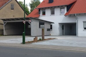 A residential street with two houses, one with a garage and the other with a covered porch. - Holiday apartment with 3 bedrooms (Werbachhausen)