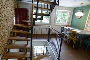 A staircase with wooden steps and metal railings, leading to a dining area with a table and chairs. - Holiday home in Oberharmersbach with sauna (Oberharmersbach)