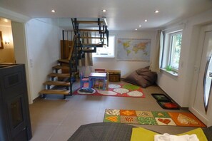 A modern interior with a spiral staircase, a dining area, a map on the wall, and a window providing natural light. - Holiday home in Oberharmersbach with sauna (Oberharmersbach)